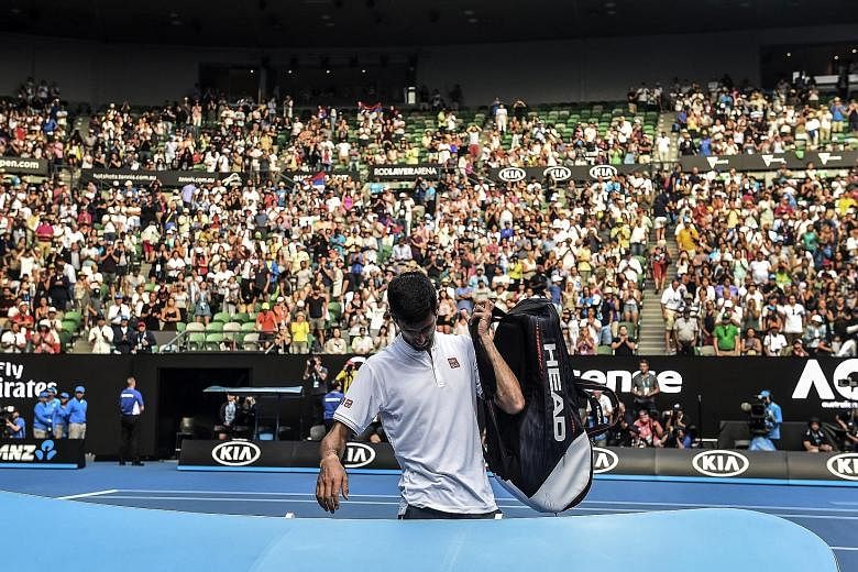 Defending champion Novak Djokovic leaving the court after his 7-6 (10-8), 5-7, 2-6, 7-6 (7-5), 6-4 loss to Denis Istomin of Uzbekistan in the second round of the Australian Open yesterday.