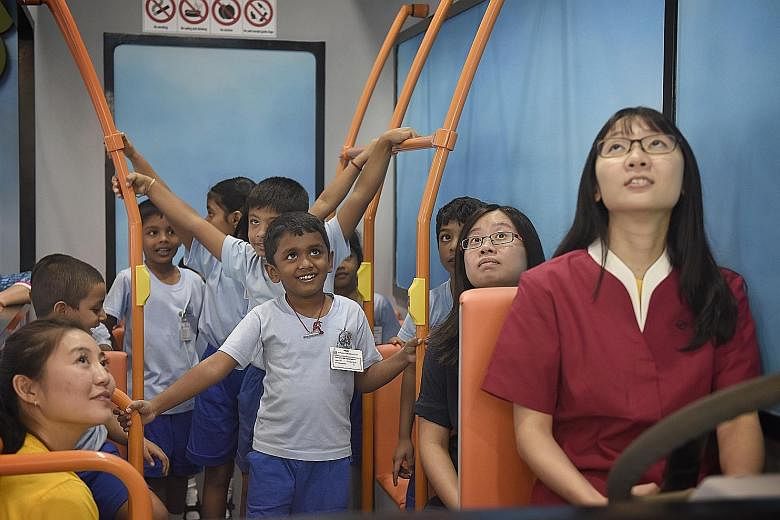 A smiling Ravi Kiran (centre), six, and 21 other children from Sarada Kindergarten yesterday became the first to board the Kindsville Express, a replica of a bus which serves as a platform to teach participants how to behave graciously on public tran