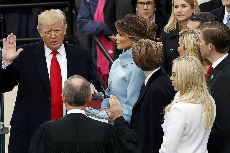 Mr Trump taking the oath of office in Washington yesterday with his wife Melania and children at his side. According to his spokesman Sean Spicer, the 45th US President will get down to business on Day 1, signing executive actions to withdraw the US 