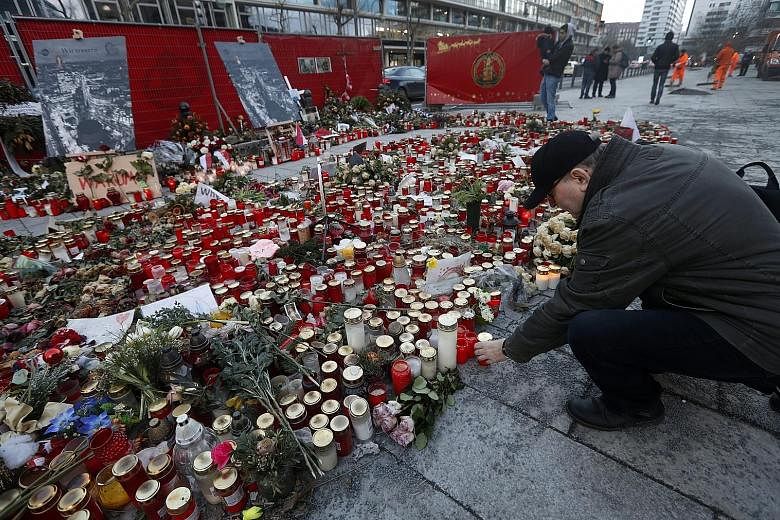 A man paying his respects on Thursday at a memorial site for victims one month after the Berlin Christmas attack carried out by a man who had been under investigation for various reasons. German Interior Minister Thomas de Maiziere said on Wednesday 