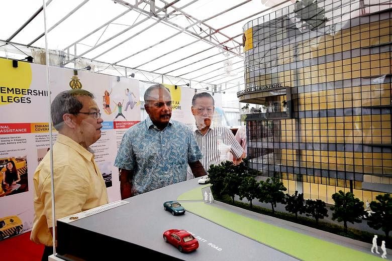 Minister K. Shanmugam viewing a model of the new AA Singapore building with chief executive Lee Wai Mun (left) and president Bernard Tay. He said partners like AA Singapore can help improve road traffic safety.