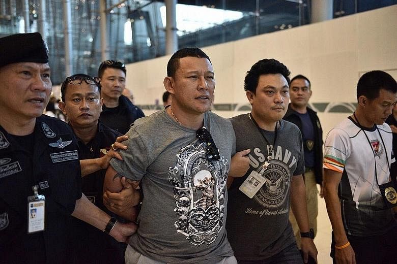 Suspected drug lord from Laos, Xayasana Keopimpha, being escorted by the police after his dramatic arrest in front of dozens of travellers at Suvarnabhumi Airport in Bangkok on Thursday.