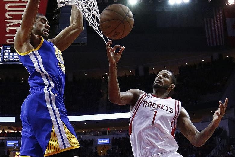 Golden State Warriors power forward James Michael McAdoo dunking over Houston Rockets guard Trevor Ariza in the second half at the Toyota Centre on Friday. McAdoo chipped in with eight points to help his league-leading side (37-6) to a 17th win on th