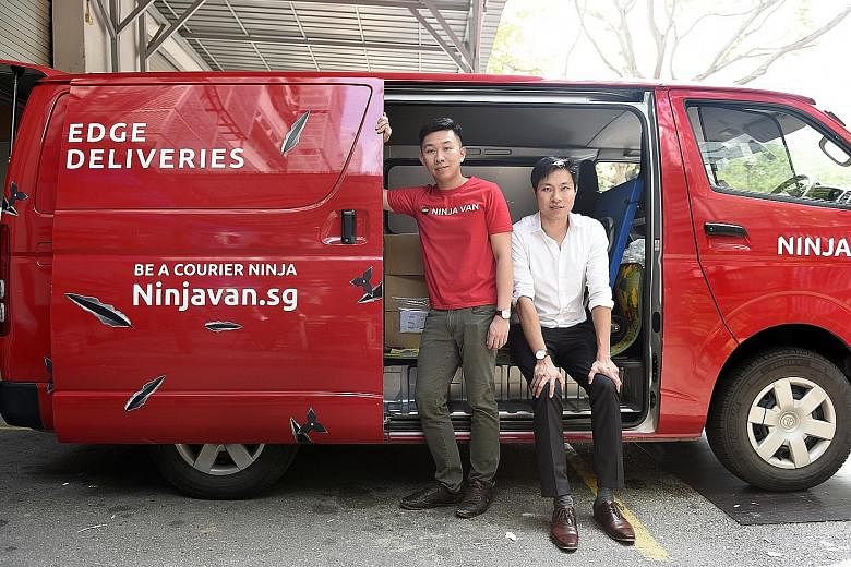 Ninja Van's Mr Pang (standing), seen here with Sunseap's Mr Tan, says his company has saved on electricity costs since switching to Sunseap's GoEco plan for one of its two facilities last month.