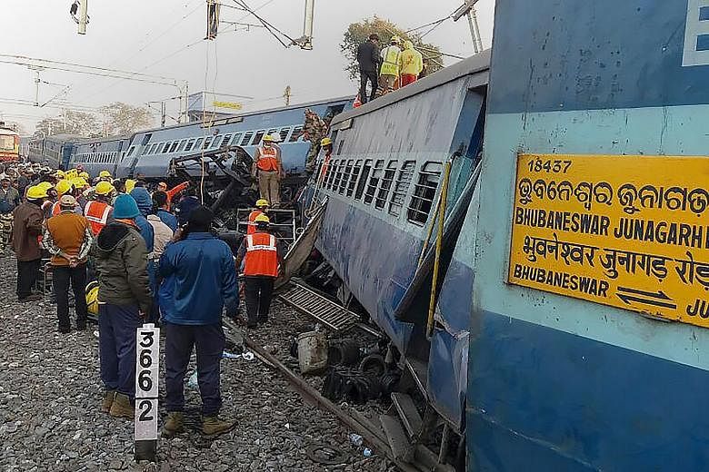 Rescue workers looking for survivors yesterday at the site of the train crash in India's southern Andhra Pradesh state. The train was travelling from the city of Jagdalpur to Bhubaneswar on Saturday night when it derailed, and officials are investiga