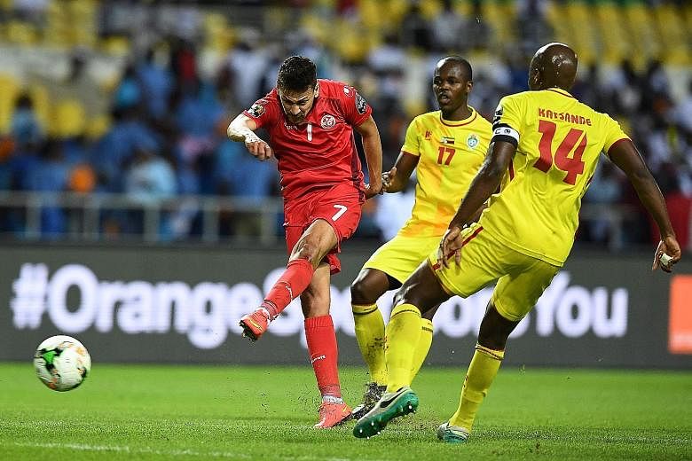 Youssef Msakni scoring Tunisia's second goal past Zimbabwe's Willard Katsande and Knowledge Musona to set his side on course for a 4-2 Africa Cup of Nations victory, sealing their place in the quarter-finals as Group B runners-up.