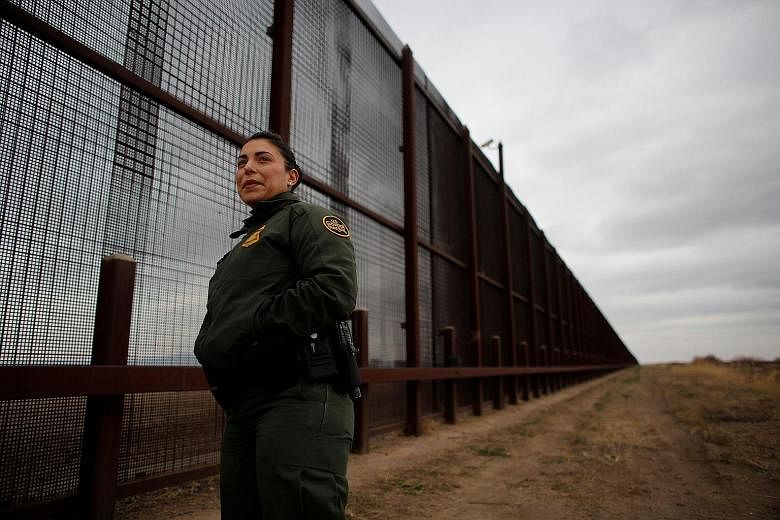 US Border Patrol agent Erika King at the fence separating the US from Mexico in El Paso, Texas. Stemming immigration was a central plank of Mr Trump's election campaign, and his signature policy was to build a wall
