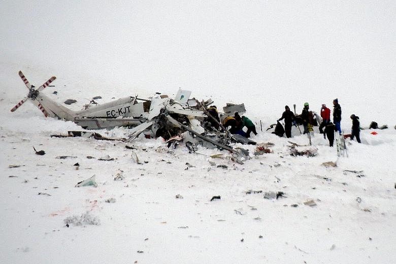 Rescue workers at the crash site in Italy's Abruzzo region on Tuesday. The helicopter was taking a skier to hospital when it crashed, dealing a fresh blow to the area that recently suffered a deadly avalanche.