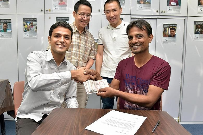 Mr Islam (right) being handed the donations by Mr Aseem, with TWC2 treasurer Alex Au (left) and TWC2 general manager Ethan Guo. Mr Islam plans to use the money to buy a plane ticket home next week and save the rest.