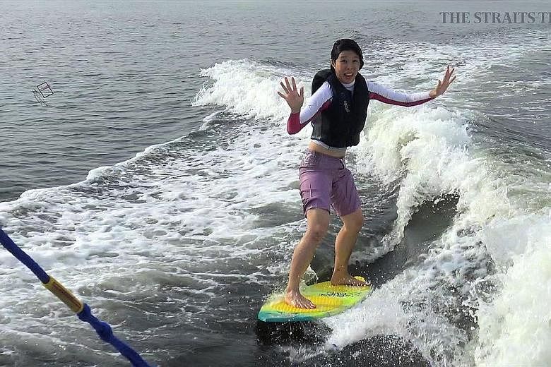 Ms Tan demonstrating wakesurfing, where you release the towline and ride in the wake of the waves created by the boat.