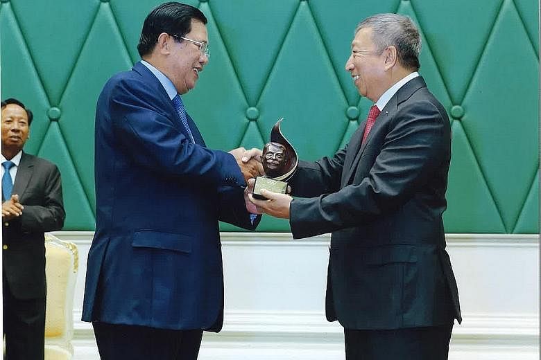 Singapore's International Olympic Committee (IOC) member Ng Ser Miang (right) presenting the IOC President's Trophy to Cambodia Prime Minister Hun Sen on Wednesday at the Peace Palace in Phnom Penh. The trophy was given in recognition of the 64-year-