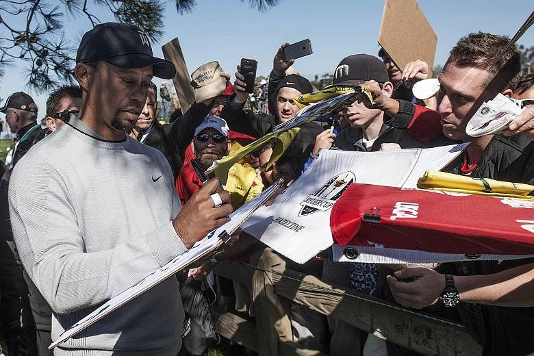 Tiger Woods signing autographs for fans following Wednesday's pro-am round before the Farmers Insurance Open at Torrey Pines, California. The US golfer says he is ready to "win tournaments" once again.