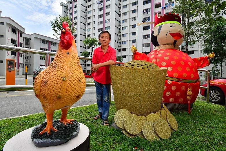 The festive decor at Block 179 prompts Mr Alan Tan (far right) to have a photo taken with his friend, Mr Yeow Thiam Teck, and the rooster statue. Mr Tan with his handiwork near Block 179, Woodlands Street 13. The carpenter has lived in the estate for