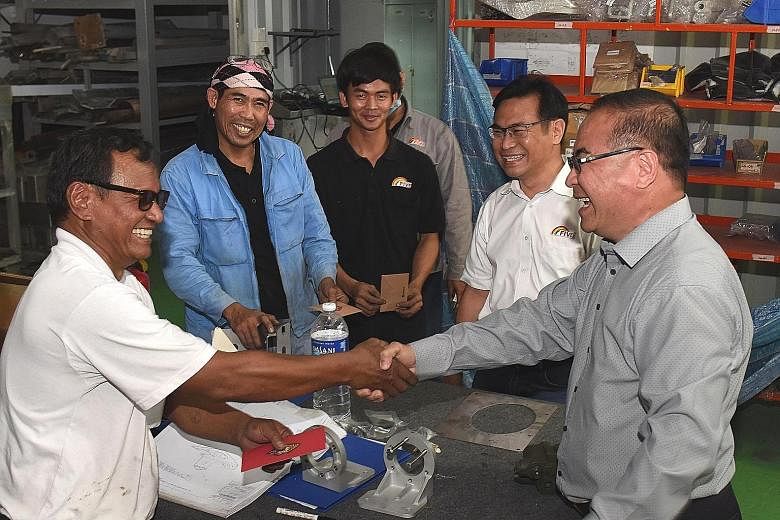 Five Aluminium Boat and Engineering managing director Edmund Long (at right) giving out red packets to his staff to thank them for their hard work and contributions in the past year.