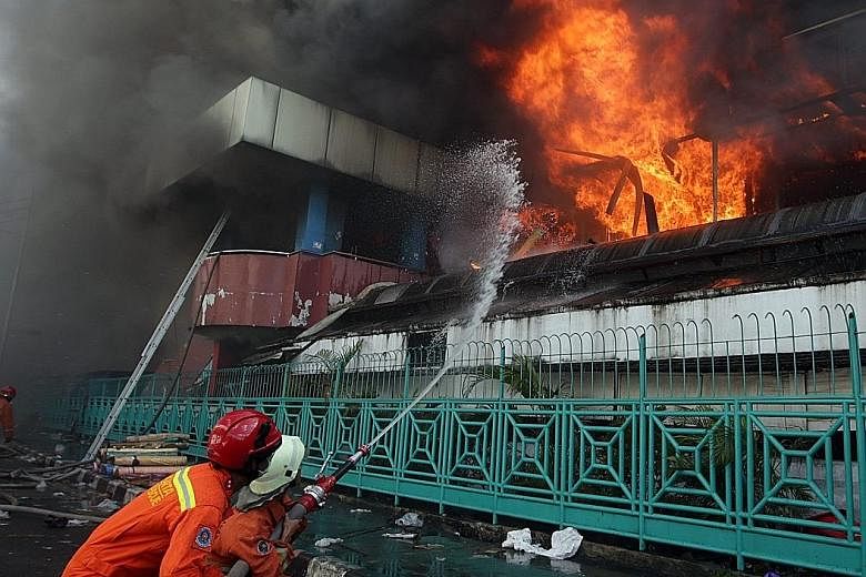 Firefighters extinguishing the fire at Pasar Senen in Jakarta on Jan 19 which razed at least 500 stalls.