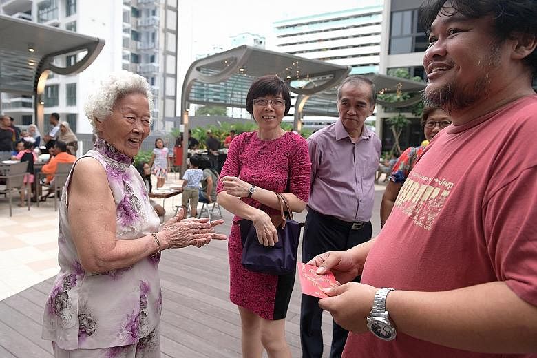 Mr Jaafar (at far right), 43, receiving a red packet from his aunt, Madam Teo Seat Lay (left), 85, yesterday. Mr Jaafar's mother, Madam Zawiah, who was adopted by a Malay family when she was an infant, sought to reconnect with her biological Chinese 