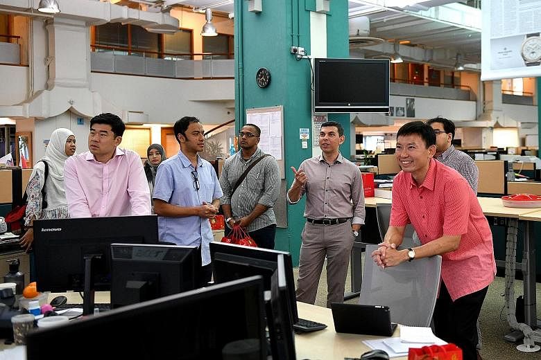 Mr Chee (right, in red shirt) in the ST newsroom last Saturday, accompanied by editor Warren Fernandez (third from right), political editor Zakir Hussain (partly hidden) and digital news editor Ernest Luis (in blue).