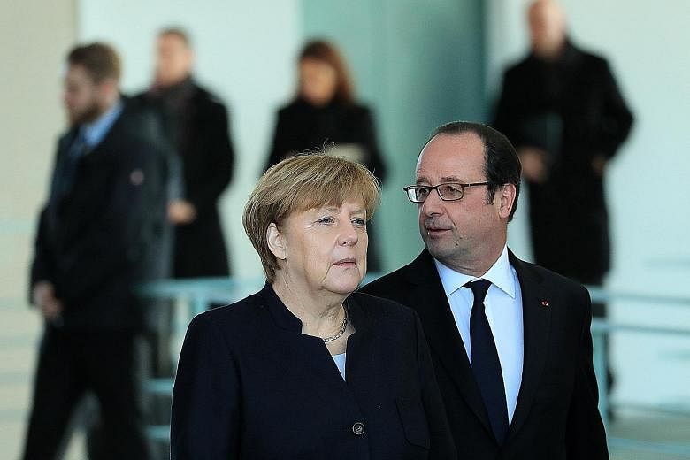 Dr Merkel and Mr Hollande at a news conference in Berlin on Friday. On Saturday, Mr Hollande vowed a "firm" response to Mr Trump's pronouncements and yesterday, Dr Merkel slammed the immigration restrictions imposed by the United States.