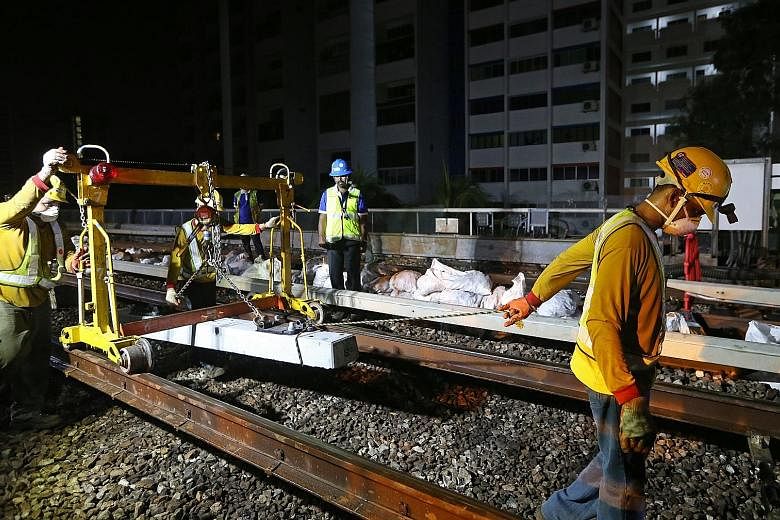 Workers replacing older timber sleepers with hardier concrete ones on the East-West Line last November. The four-year project to upgrade the sleepers on the North-South and East-West lines was completed last month.