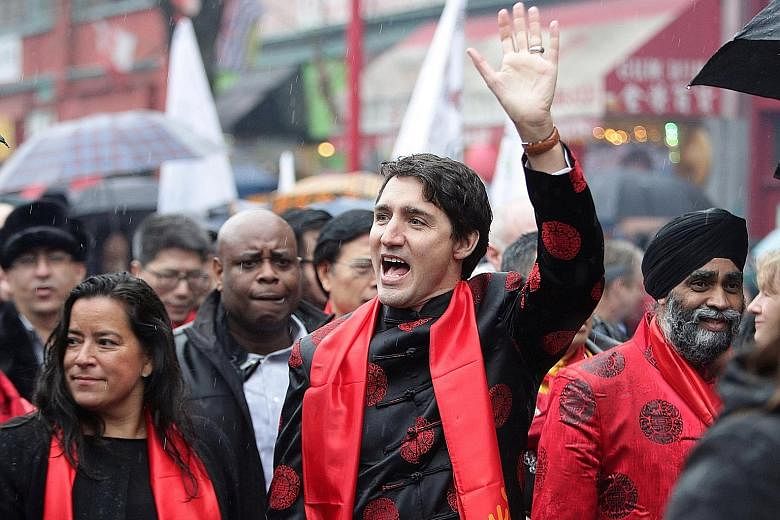 Children in traditional outfits among the crowd celebrating Chinese New Year at a firecracker ceremony in New York's Chinatown last Saturday. Mr Trudeau (centre) at a Chinese New Year parade in Vancouver with (from far left) Minister of Justice Jody 