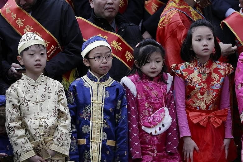 Children in traditional outfits among the crowd celebrating Chinese New Year at a firecracker ceremony in New York's Chinatown last Saturday. Mr Trudeau (centre) at a Chinese New Year parade in Vancouver with (from far left) Minister of Justice Jody 