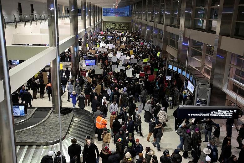 Volunteer lawyers setting up camp at Chicago's O'Hare Airport on Sunday to help immigrant travellers and their families after Mr Trump issued an executive order on immigration. Protesters gathering at the baggage claim area of Detroit Metropolitan Ai