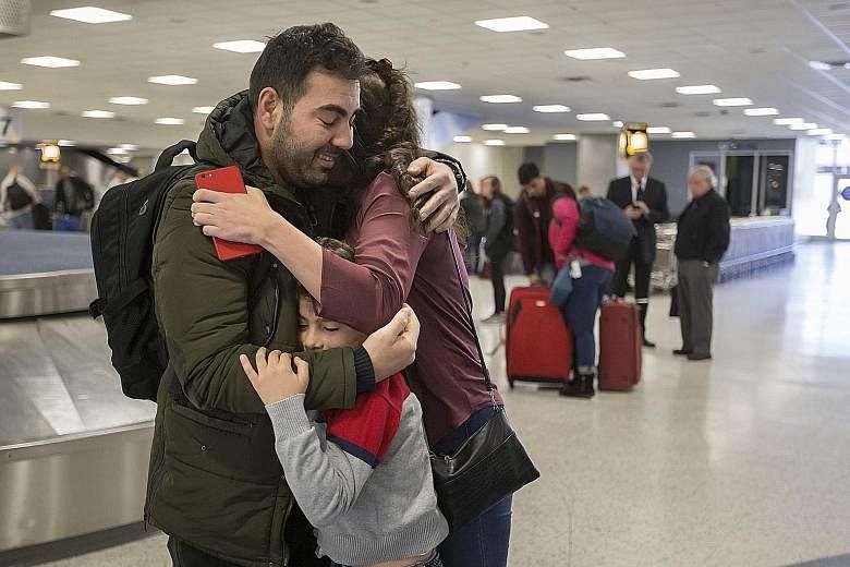 Baghdad-born accountant Haider Sameer Abdulkhaleq Alshawi back with his family at the airport in Houston on Sunday, after being detained in New York the previous day following Mr Trump's executive order on immigration.