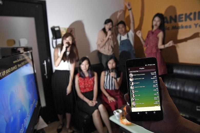 Customers having a karaoke session at Manekineko using the firm's MyKara app. The karaoke chain offers secured Wi-Fi for customers to surf the Internet and to control the song-selection system.