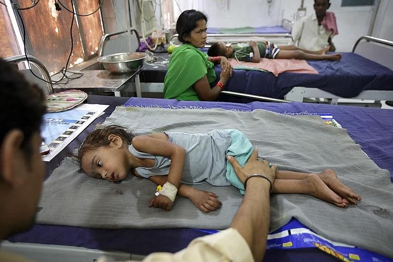 A parent comforts his two-year-old daughter at the Sri Krishna Medical College Hospital in Muzaffarpur, India. A medical investigation into a deadly illness that has been afflicting hundreds of children in India has found an unlikely culprit: lychees