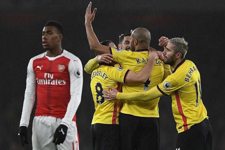 Younes Kaboul celebrating his opener against Arsenal with his team-mates. Watford condemned Arsenal to a damaging 2-1 Premier League defeat at the Emirates.