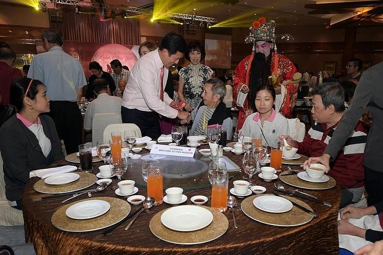 Minister Ong giving a hongbao to a resident of the Sunshine Welfare Action Mission at the Singapore Maritime Officers' Union's annual Chinese New Year luncheon. To Mr Ong's left is the union's general secretary, Ms Mary Liew.