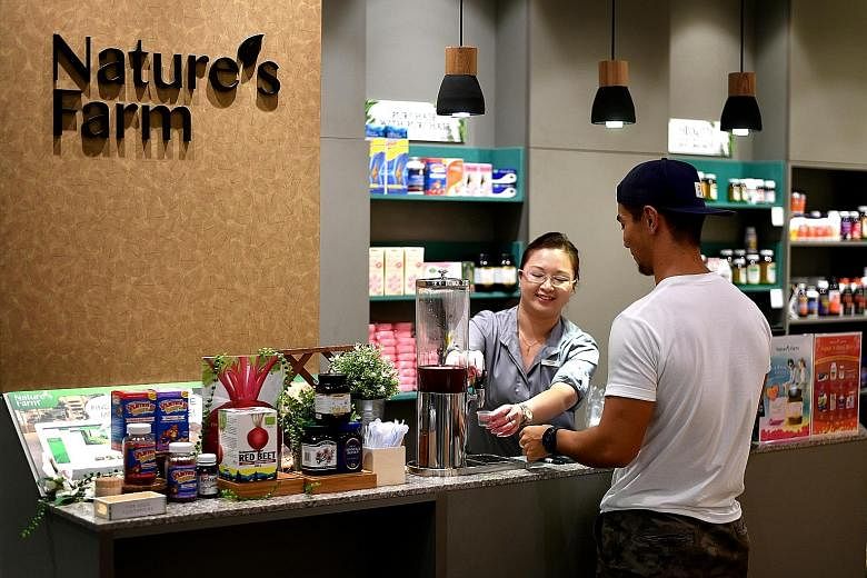 Nature Farm's revamped Parkway Parade store includes a sampling bar for customers (above) to try selected supplements (left), and wider aisles and a seating area (above).