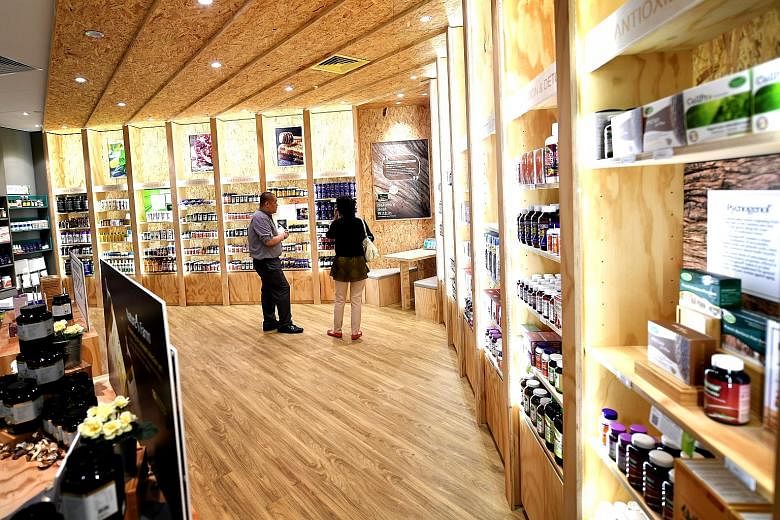 Nature Farm's revamped Parkway Parade store includes a sampling bar for customers to try selected supplements (left), and wider aisles and a seating area (above).