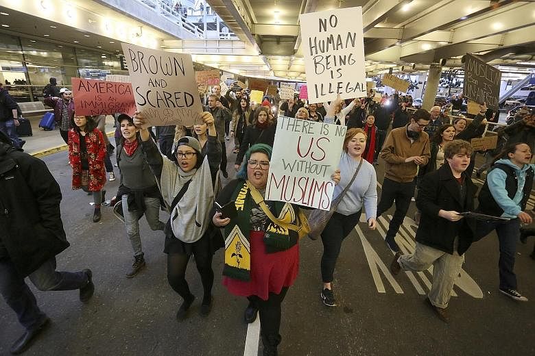 Activists have gathered outside US airports, as seen here at Portland International Airport on Jan 29, to protest against Mr Trump's travel ban.