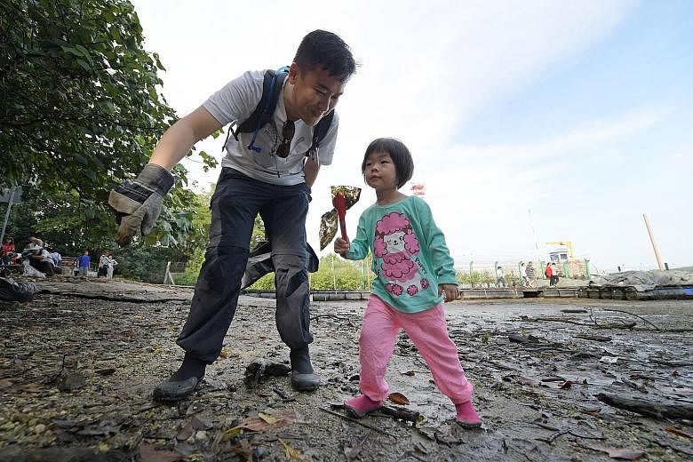Programme manager Adrian Lim and his daughter Elizabeth were among the 67 volunteers cleaning up the Lim Chu Kang mangrove yesterday (below). "People should know that there's all this nature right in our backyard, but there's also all this trash," sa