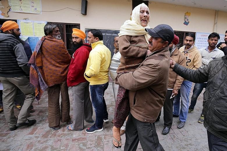 A 90-year-old woman being carried to a polling station in Amritsar yesterday. BJP may lose in Punjab where it has been in power with its partner since 2007, as the Congress party may make a turnaround.