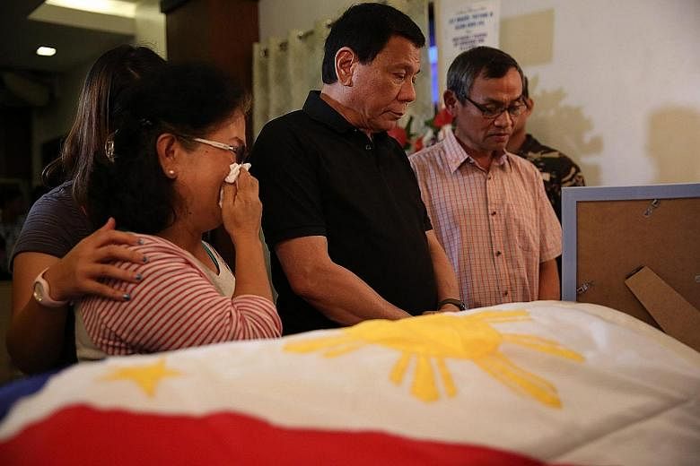 Mr Duterte with the family of Second-Lieutenant Miguel Victor Alejo at the soldier's wake last Saturday, after he was killed by the NPA. Mr Duterte has condemned the insurgents for resuming hostilities.