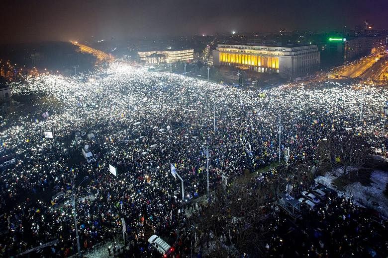 Protesters lighting up the Victoriei Plaza, outside the Romanian government headquarters in Bucharest, on Sunday, demanding the Cabinet resign.