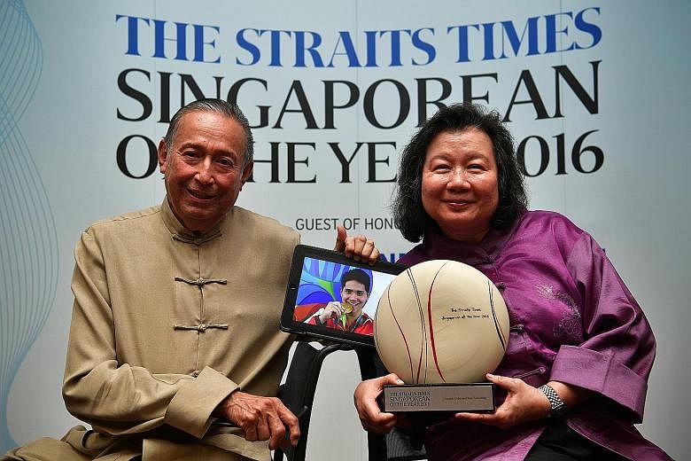 Colin and May Schooling with The Straits Times Singaporean of the Year 2016 award and an Olympic picture of Joseph during the award ceremony yesterday. Guests were told to come in festive dress, since the event was held during the Chinese New Year pe