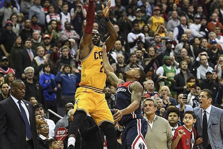LeBron James of the Cleveland Cavaliers shooting a dramatic three-pointer over the Washington Wizards' Bradley Beal to tie the score at 120-120 and force the game into overtime on Monday. The Cavaliers went on to wrap up a 140-135 victory.