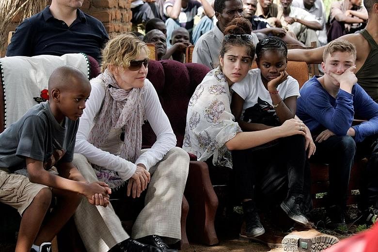 Madonna (second, from left) with her children in Malawi in 2013. The pop star adopted twin girls yesterday, adding to the two other children she had adopted earlier from the country.