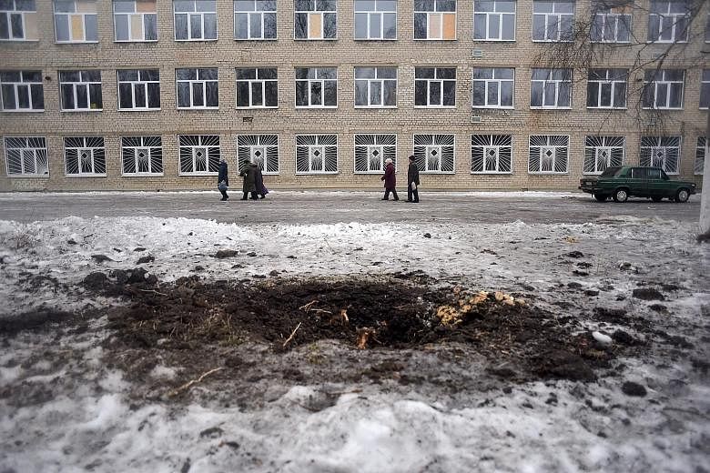 A shell hole is seen in front of a school in Avdiivka, Donetsk area, Ukraine, on Monday. Ukrainian forces and pro-Russian separatists have both blamed each other for the latest flare-up as the two-year-old Minsk peace deal has merely locked the two s