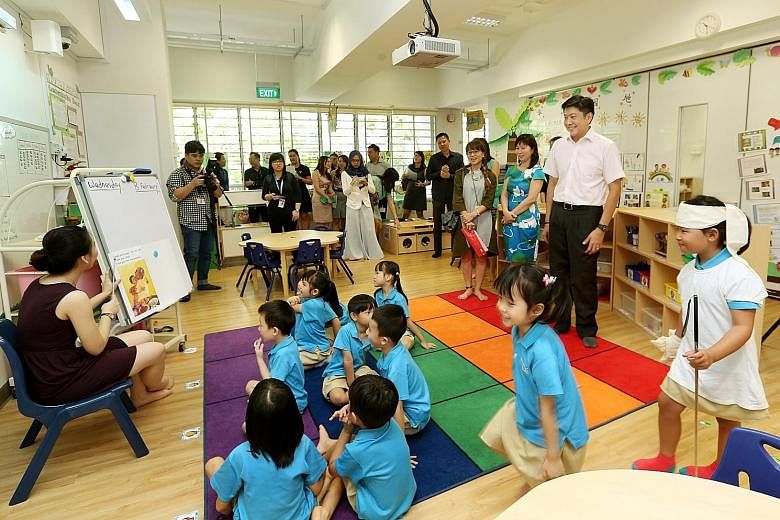 Education Minister (Schools) Ng Chee Meng (far right) visiting the MOE Kindergarten @ Punggol View yesterday, with Ms Panmeline Wong, head of the centre, beside him. To be set up in Punggol next year, the three new MOE kindergartens will be co-locate