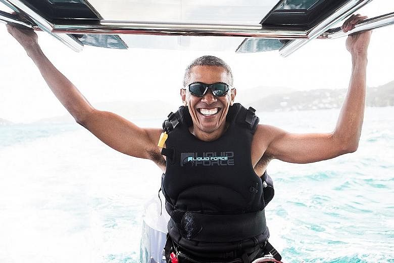 Left: Mr Obama relaxing with Mr Branson on a boat off the coast of Moskito Island, which is owned by the Virgin Group founder. Below: Mr Obama spent two days learning kitesurfing, in which people ride a board while being pulled behind a kite, Mr Bran
