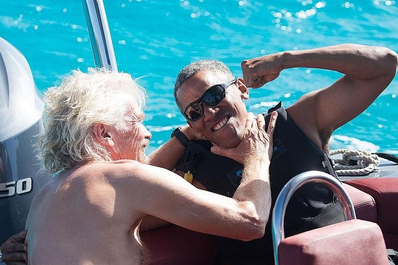 Left: Mr Obama relaxing with Mr Branson on a boat off the coast of Moskito Island, which is owned by the Virgin Group founder. Below: Mr Obama spent two days learning kitesurfing, in which people ride a board while being pulled behind a kite, Mr Bran