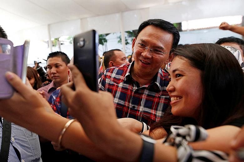 Basuki, seen in a file photo taken last November, is seeking a fresh term in the gubernatorial election next Wednesday. He has been accused of insulting Islam at an event last September.