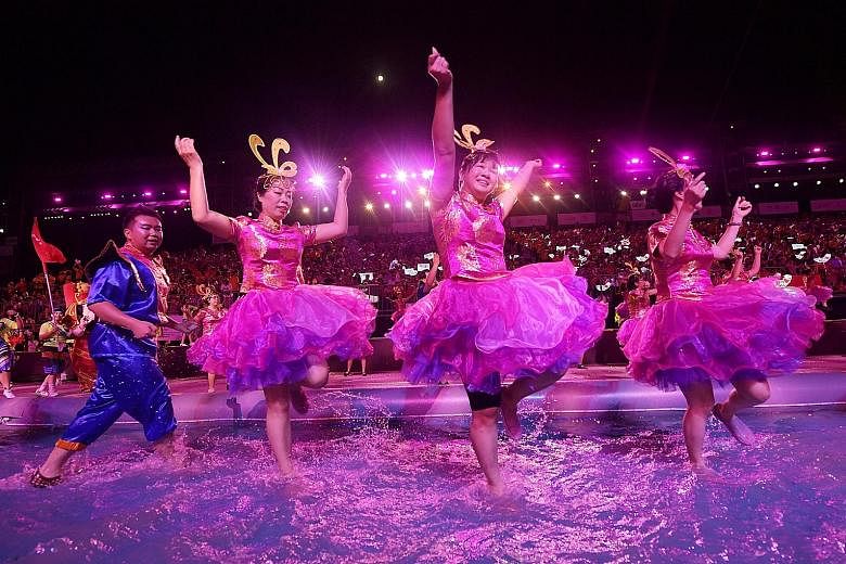 Performers simulating a dragon boat race in one of the segments in the show, which also featured iconic performances from the 1970s. Left: Water from a mock moat splashed onto the audience last night as dancers frolicked in it. Above: Traditional Chi