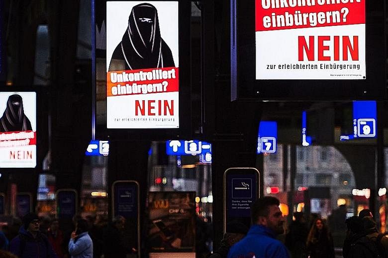 Posters of a niqab-clad woman with the words "Uncontrolled Naturalisation? No" in a Zurich train station. The posters were commissioned by the Committee Against Facilitated Citizenship. The issue in tomorrow's vote is whether the grandchildren of imm