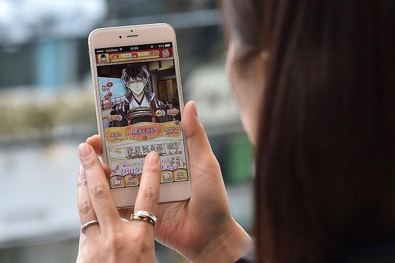 A fan of dating simulation games playing the popular Ikemen series last week. The app, which has been downloaded some 15 million times, offers different scenarios for users to create their own love stories.