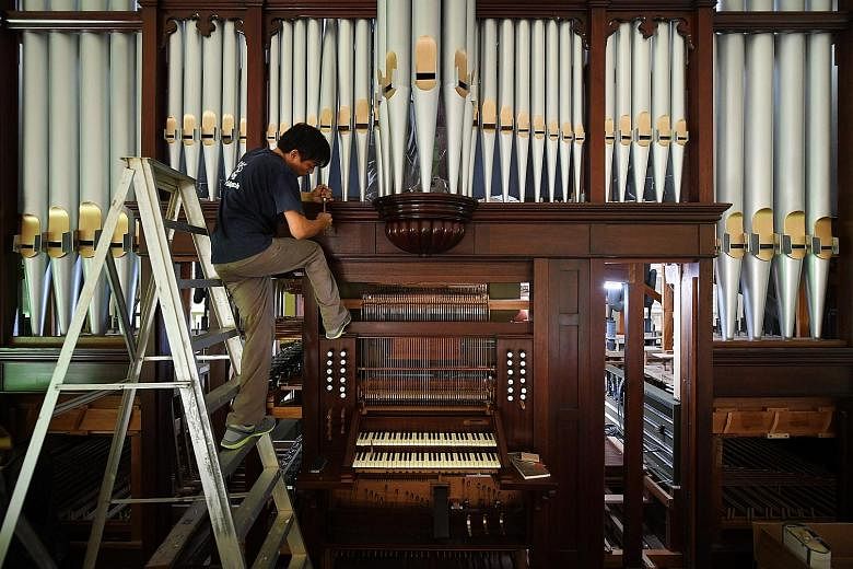 Organ builder Cealwyn Tagle (above) adjusted various parts of each pipe by carefully tapping the metal parts or shaving off tiny bits of wood until it "spoke" with the correct sound. The 105-year-old pipe organ had to be taken apart and reassembled d